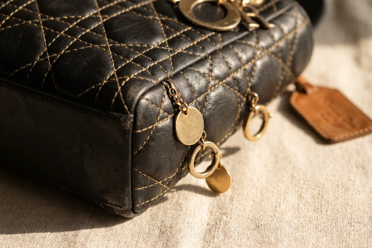 Grande plano do acolchoado cannage e dos pendentes, pormenores que variam entre tamanhos Lady Dior e épocas