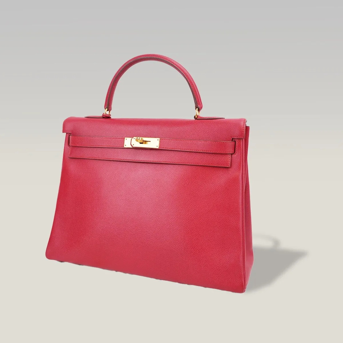 Pre-owned vintage Hermès Kelly 35 in red leather with gold-plated hardware, its Hermès date stamp hidden under the strap